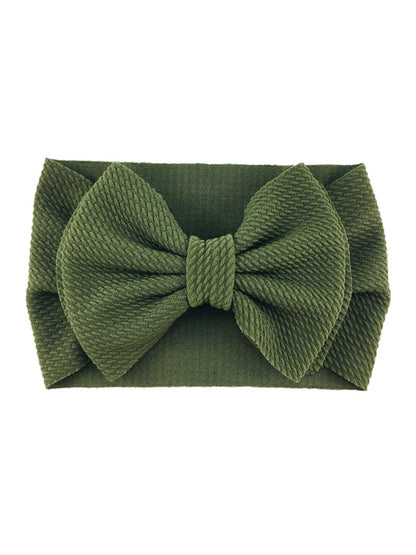 Green textured headband with a large bow, ideal for stylish hair accessories.