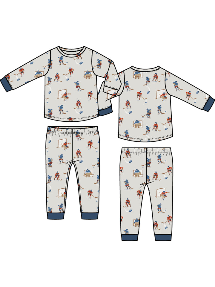 Children's hockey-themed pajama set featuring long sleeves and pants with playful athlete illustrations.