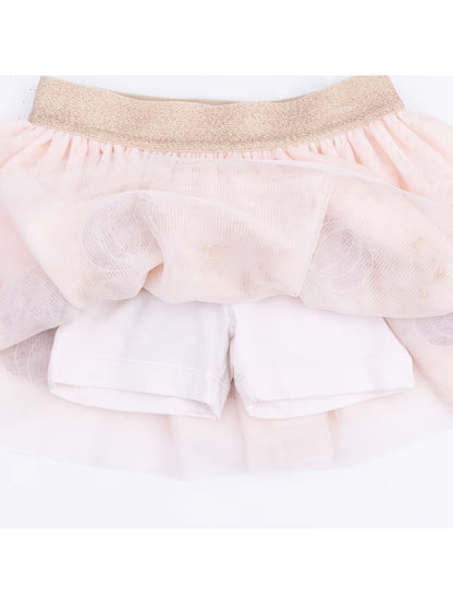 Pale pink tutu skirt with gold waistband overlaying white shorts.