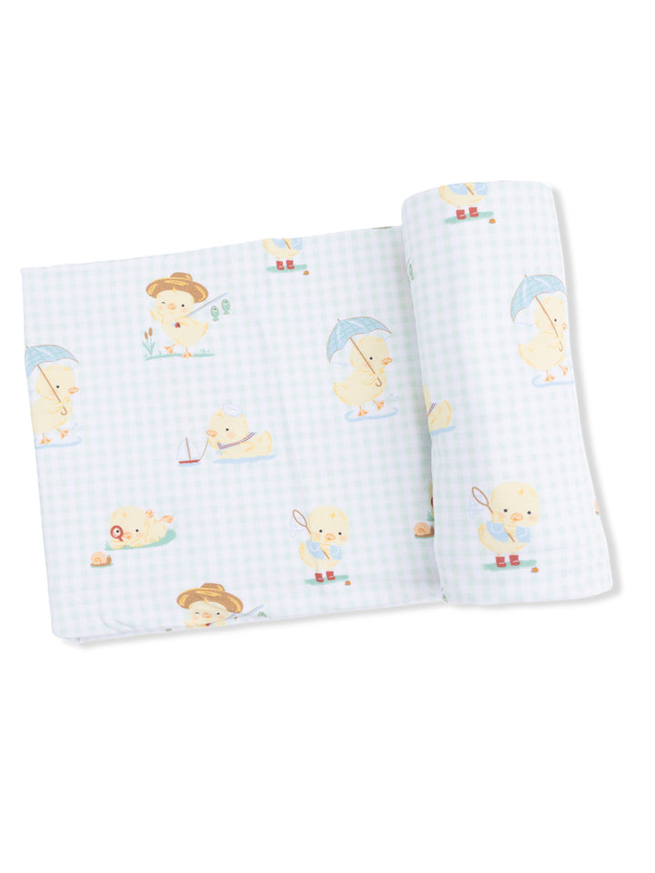 Light blue fabric featuring playful duck illustrations in various childhood activities.