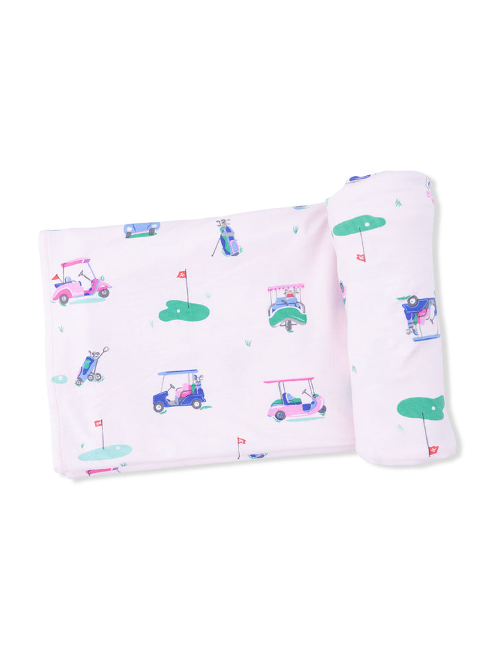 Light pink blanket featuring playful golf cart patterns and green accents.