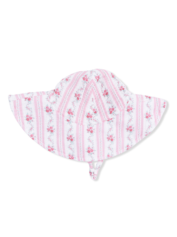 Floral-patterned sun hat in shades of pink with wide brim and chin strap. Ideal for sun protection.