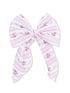 Pink floral-patterned hair bow with striped design and long tails. Perfect accessory for a sweet look.