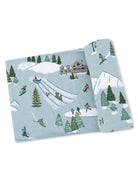 Ski-themed patterned fabric featuring skiing, snowboarding, and trees in a winter setting.