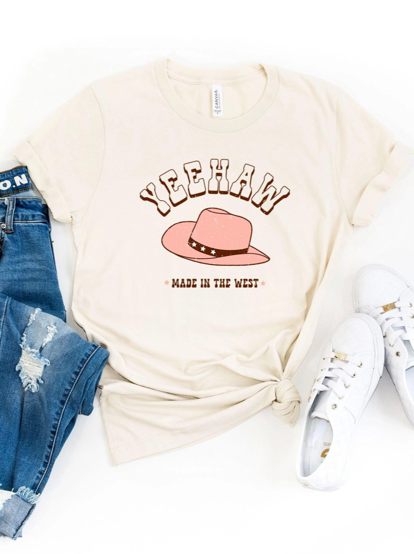 Cream t-shirt with "YEEHAW" and a pink cowboy hat graphic, paired with distressed jeans and white sneakers.