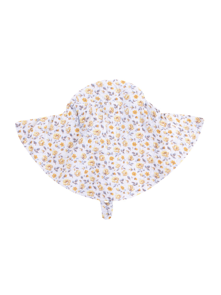 White sun hat with yellow floral pattern, wide brim, and tie at the back for secure fit.