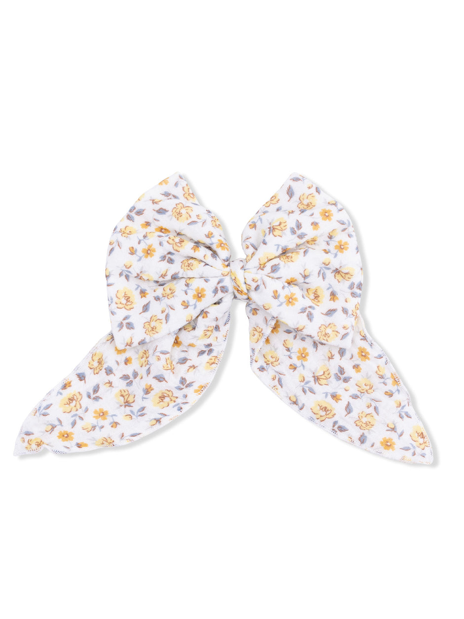 White floral hair bow with yellow and lavender flowers, tied in a large bow shape.