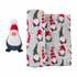Plush gnome toy beside a fabric featuring festive gnome patterns on a light gray background.