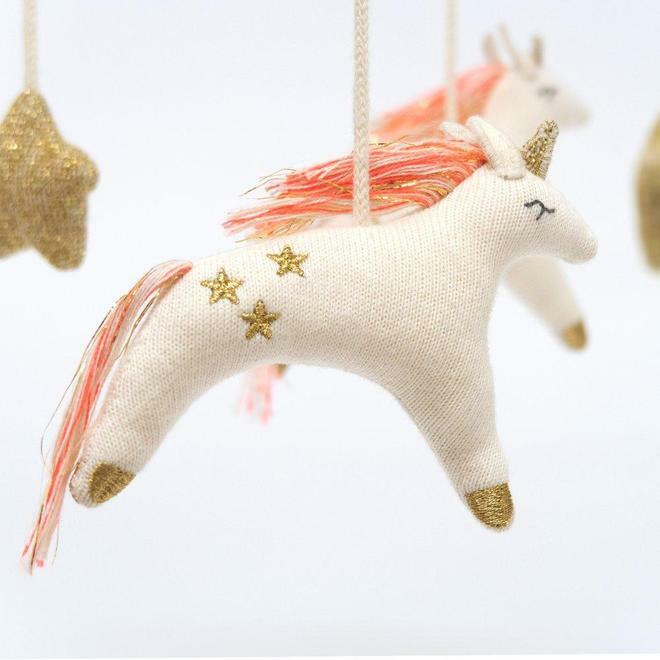 Hanging plush unicorn decorations with golden stars and colorful manes on a light background.