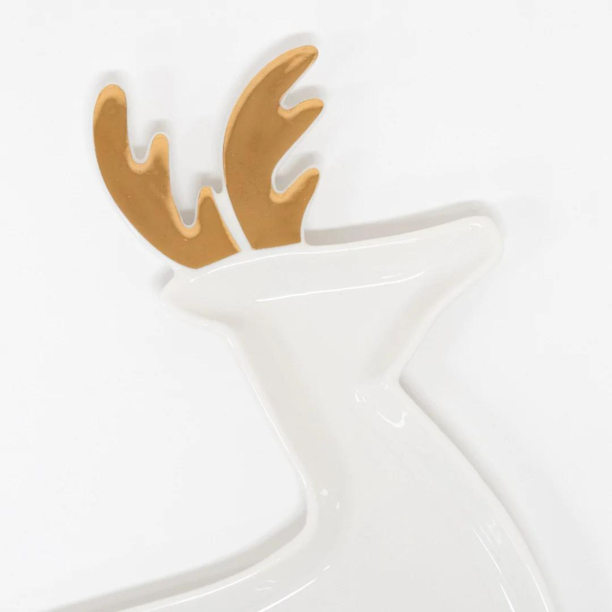 White dish shaped like a reindeer with gold antlers, ideal for decorative or serving purposes.