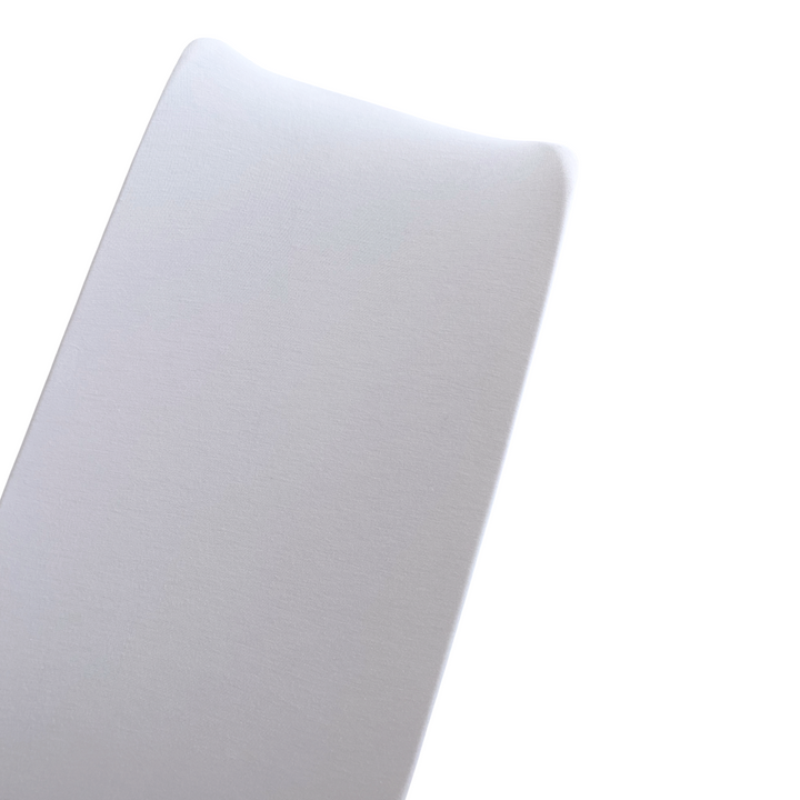 Close-up of a smooth, white surface reflecting light, suggesting a soft texture and contemporary design.
